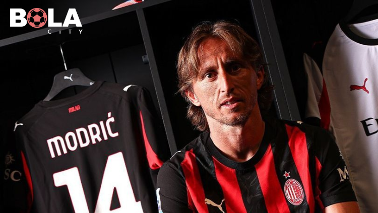 Luka Modrić mengenakan jersey AC Milan di ruang ganti dengan seragam bernomor punggung 14 tergantung di belakangnya setelah diperkenalkan sebagai pemain baru.