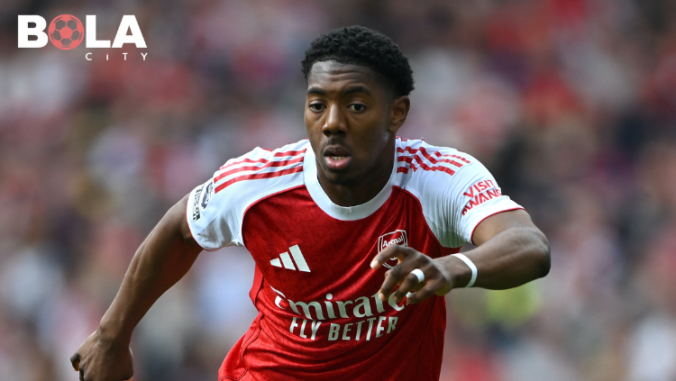 Myles Lewis-Skelly pemain Arsenal merayakan gelar Premier League 2026 dengan melihat logo emas di lengan bajunya, bintang muda incaran Manchester United
